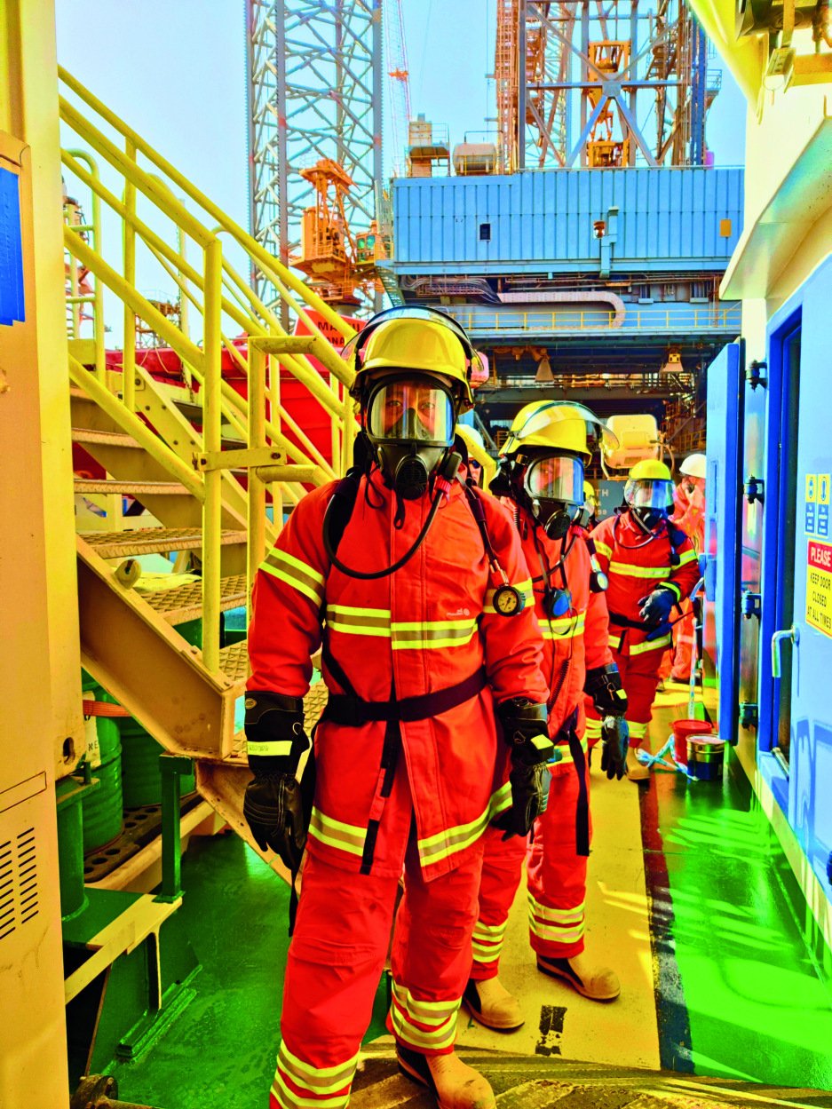 Offshore emergency response team in full FR-rated PPE on an oil platform